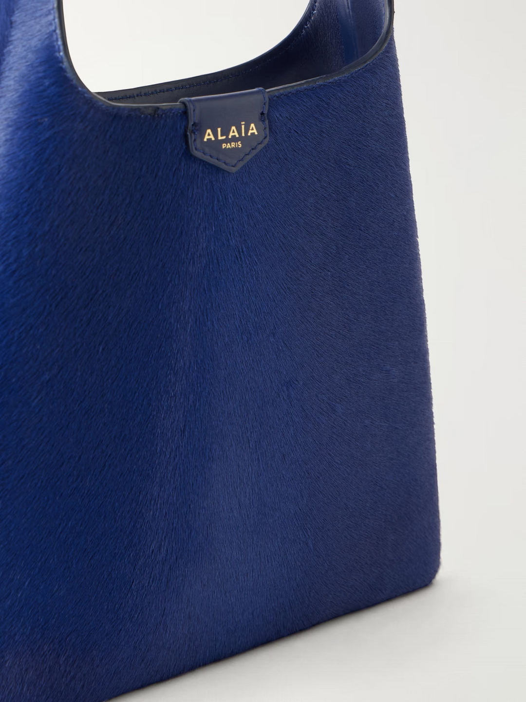 GLAM MODA Alaïa deep blue calf hair shoulder bag with a slouchy open design and leather shoulder strap