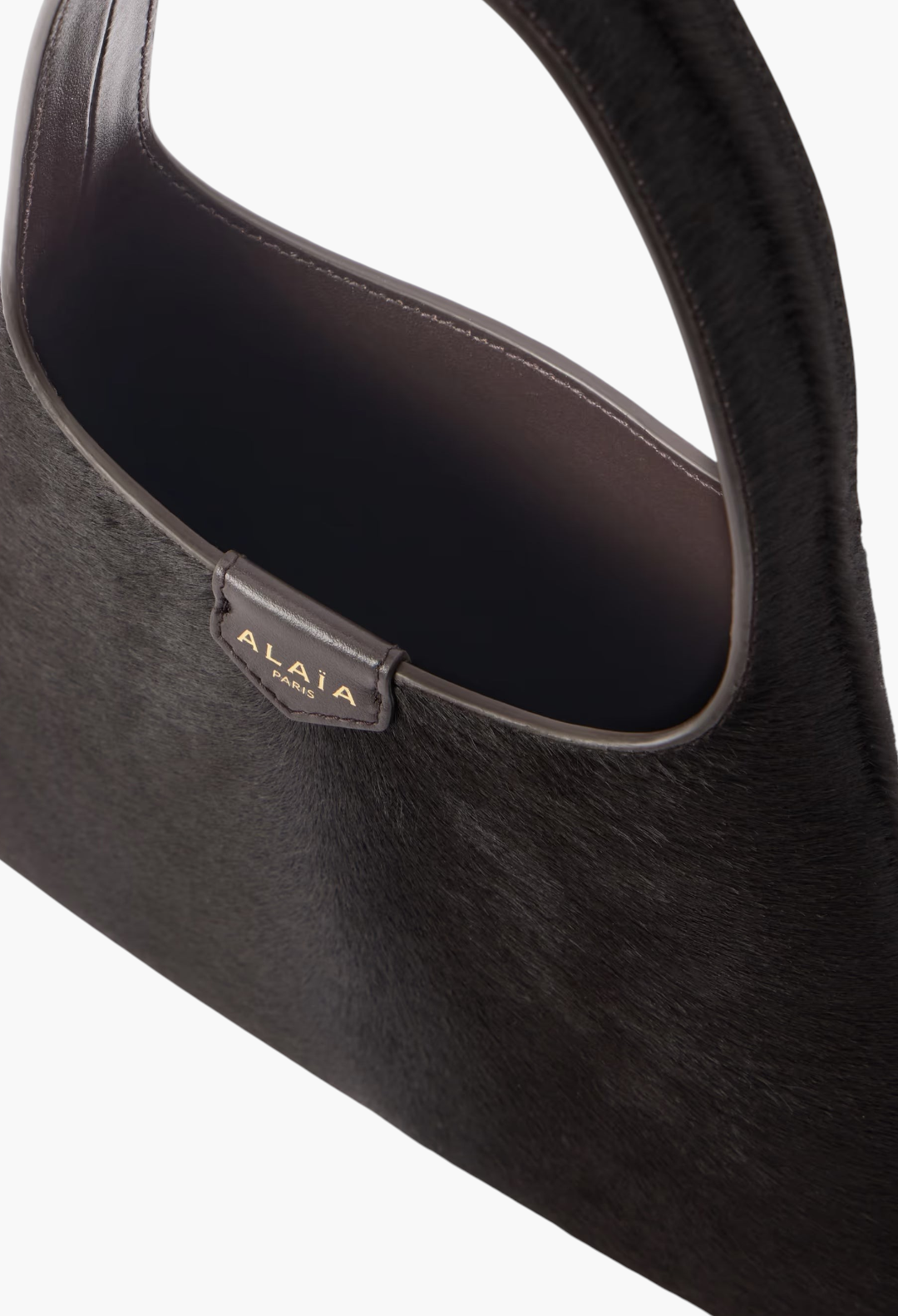 GLAM MODA Alaïa mini shoulder bag in dark brown calf hair with a slouchy silhouette and leather shoulder strap
