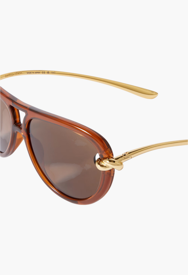 GLAM MODA Bottega Veneta New Knot aviator sunglasses featuring brown frames and gold-tone twisted metal temples.